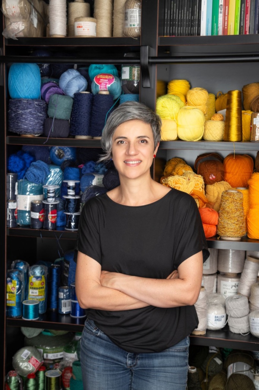 Janaina Mello Landini in front of a storage full of her various working materials.